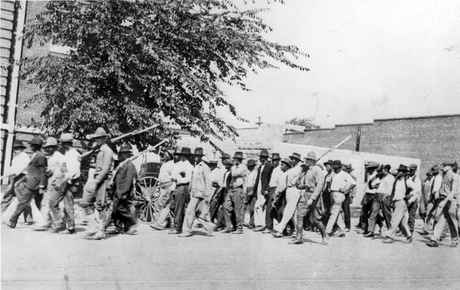 Tulsa Yarış Katliamı, Tulsa, Oklahoma, Haziran 1921'den sonra, süngü takılı tüfekler taşıyan bir grup Ulusal Muhafız askeri, silahsız Siyah erkeklere bir gözaltı merkezine kadar eşlik ediyor.