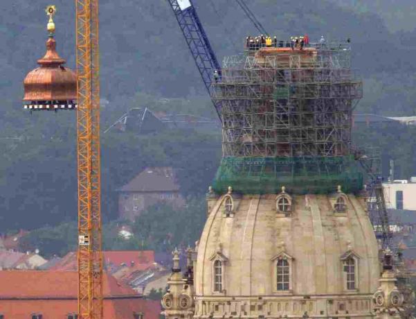 Bir bakır bakır kubbe ve altın haçı Dresden, Almanya'da yeniden inşa edilmiş Frauenkirche üstüne kaldırdı