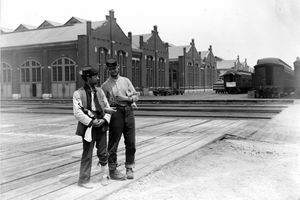 İki asker Pullman Binası'nın yanında duruyor ve 1894 Chicago Pullman Strike sırasında kilitli kolları ve bir şişe likörü olan arabaları eğitiyor