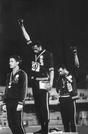 Afro-Amerikan ABD pist takımı üyeleri Tommie Smith ve John Carlos, Mexico City'deki 1968 Olimpiyatları'nda madalya töreni sırasında siyah güç yumruklarını sivil haklar protestosu olarak yetiştiriyor