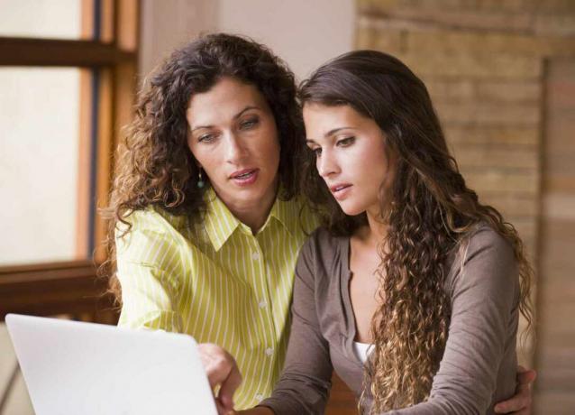 Dos mujeres llenando planilla en computadora