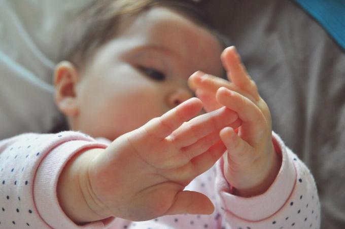 Yatakta yatarken kız bebek yüksek açılı görünüş