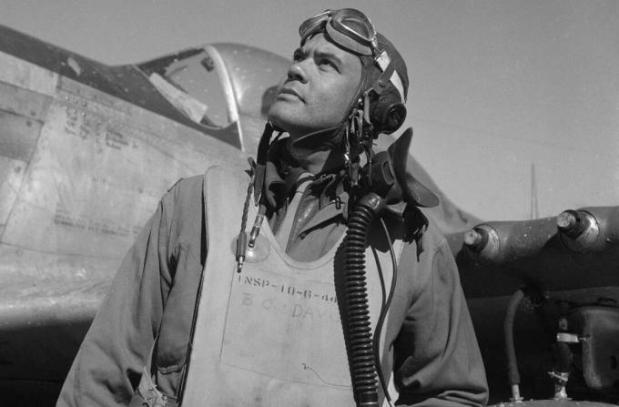 Benjamin O. Davis bir uçuş takım elbise ve kask ayakta bir P-51 Mustang savaşçı önünde.