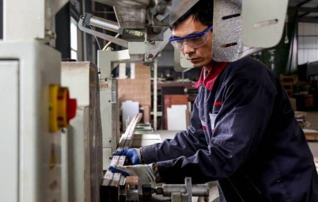 Çin'in doğu Shandong eyaletindeki Zouping'deki bir fabrikada alüminyum ürünler üzerinde çalışan bir çalışan