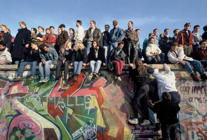 İnsanlar kutlama için 10 Kasım 1989'da Berlin Duvarı'na tırmanıyor.