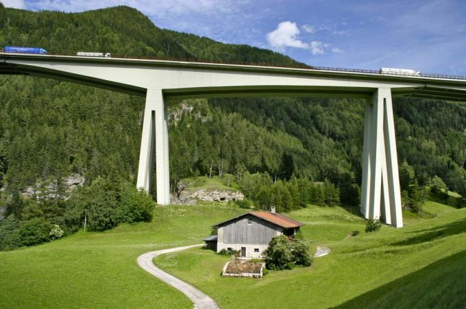 Avrupa'nın dağları, vadileri ve Alp evlerinin üzerinde yükselen beton köprü