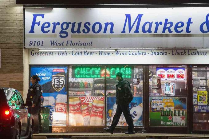 Missouri, Ferguson'daki 2014 isyanları sırasında Ferguson Pazarı ve Likörü önünde polis memurları.