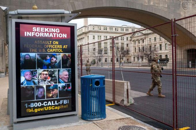 Bir Ulusal Muhafız, 19 Ocak 2021'deki ABD Kongre Binası saldırısıyla ilgili bilgi arayan bir posterin önünden geçiyor.